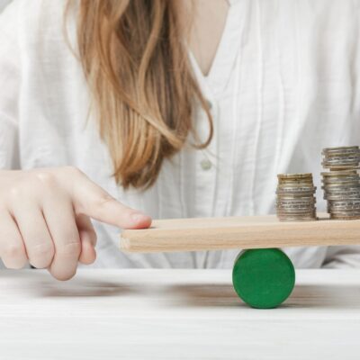 woman-holding-her-finger-balance-with-coins woman-holding-her-finger-balance-with-coins